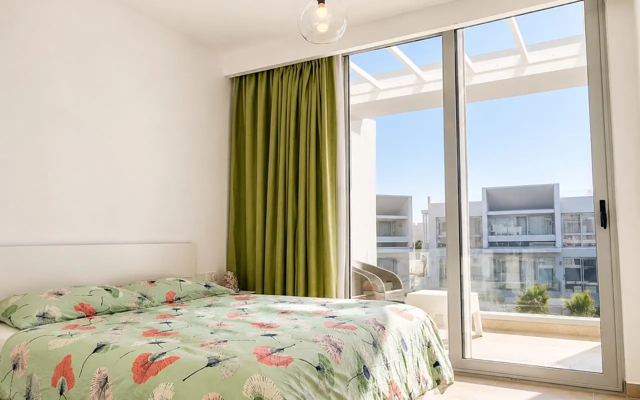 Bedroom opening onto a balcony with resort view