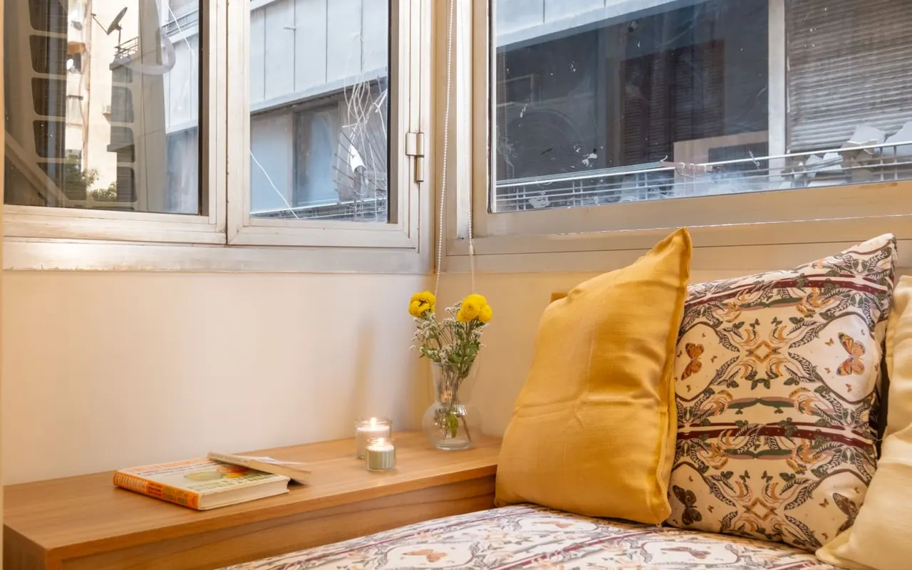 Bedroom window nook with cushions and fresh flowers