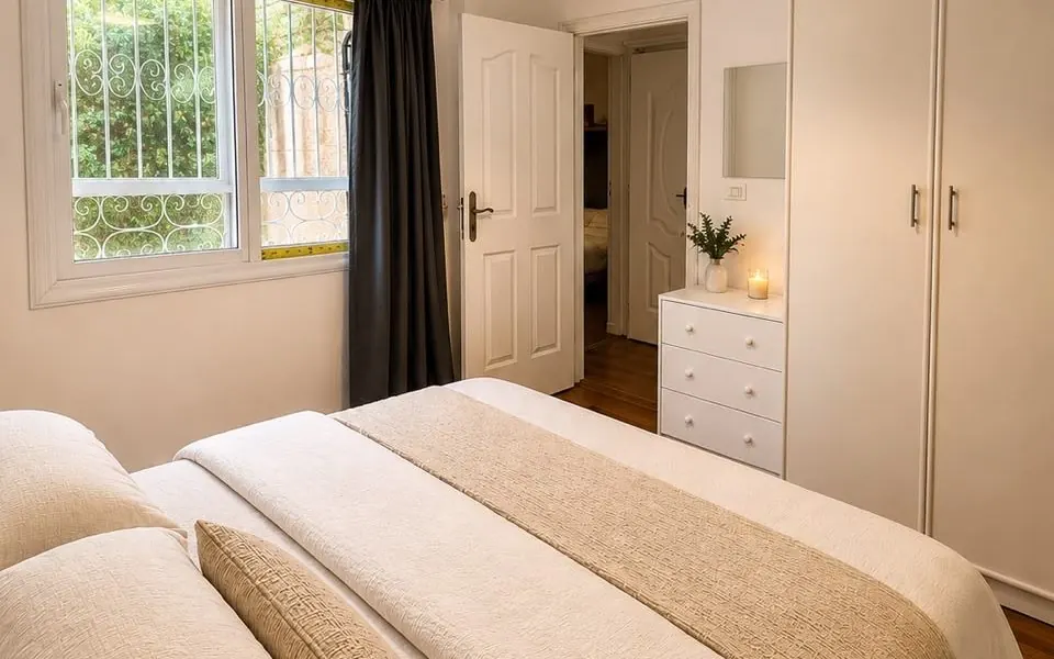 Bedroom with neutral linens and garden window