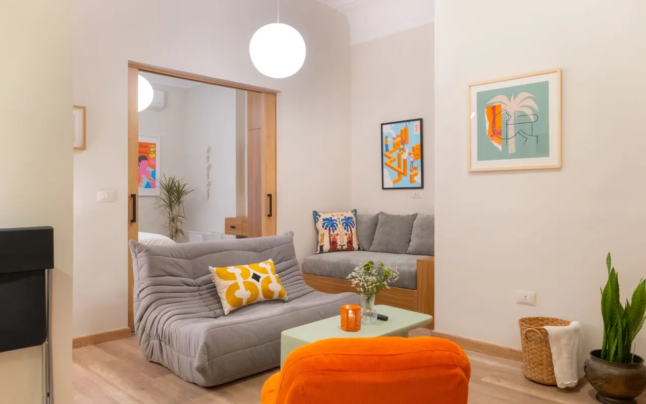 Funky Downtown Flat — living room with a designer sofa and orange pouf
