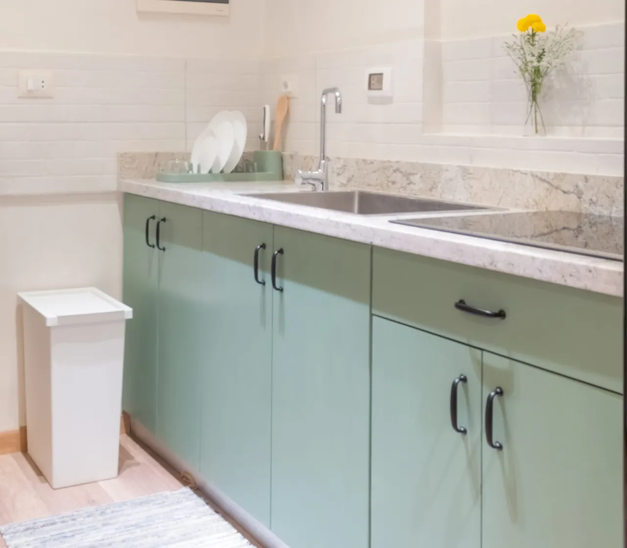 Kitchen with sage-green cabinets and a marble counter