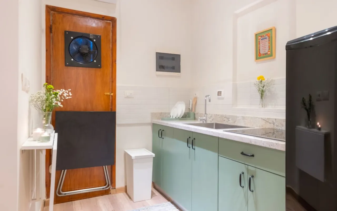 Kitchen with sage-green cabinets and marble counter