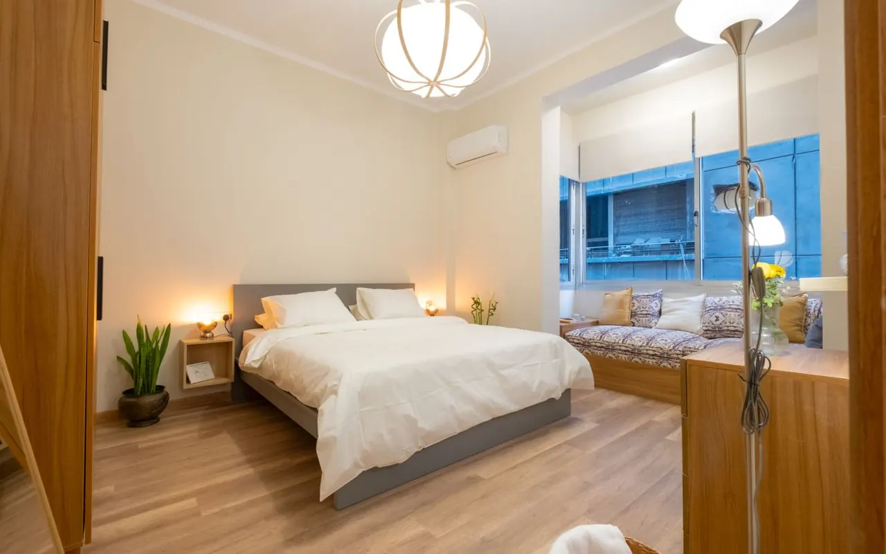 Main bedroom with warm lighting and a window nook
